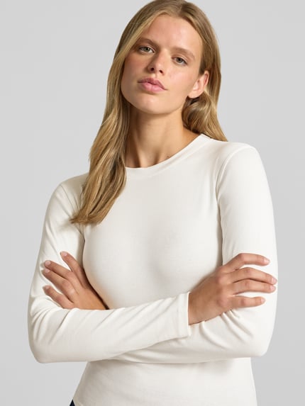 Frauenmodel trägt Longsleeve mit Rundhalsausschnitt Modell 'EVERYDAY' von TOPSHOP in Weiß, fein strukturiert, Baumwolle, Nahaufnahme Oberkörper.