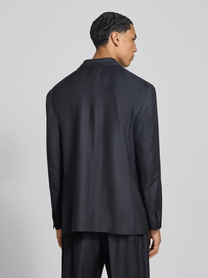 Männermodel trägt Regular Fit Sakko aus Woll-Mix von Officine Générale in dunklem Farbton, strukturierter Stoff, Ganzkörperansicht Rückansicht. Rückenlänge 78 cm, Schulterbreite 47 cm, Ärmel 59 cm, Woll-Kaschmir-Mix mit Seide, Doppelreiher, Paspeltaschen, Reverskragen.