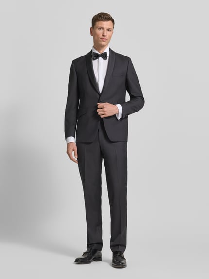 Männermodel trägt schwarze Stoffhose mit Bundfalten von Wilvorst aus Baumwoll-Mix, gerader Schnitt, Ganzkörperansicht von vorne.