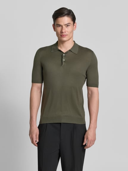 Mannenmodel draagt Slim Fit Poloshirt aus reiner Seide van GRAN SASSO in olijfgroen, korte mouw, polokraag, semitransparant, vooraanzicht, ruglengte 68 cm bij maat 50.