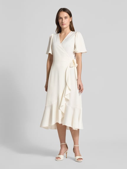 Vrouwenmodel draagt Regular fit midijurk in wikkel-look model 'Thea' van YAS, kort mouwontwerp, ruches, lichte stof, volledig frontaal.