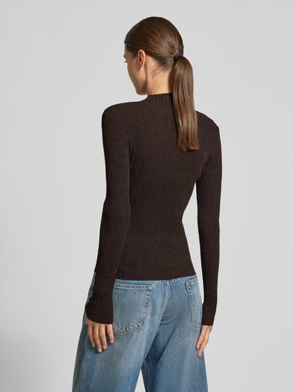 Frauenmodel trägt Slim Fit Rollkragenpullover mit Glitzergarn Modell 'Isabel' von GUESS in dunklem Braun, Strick-Optik, Ganzkörperansicht Rückansicht.