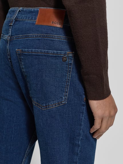 Męski model nosi Regular Fit Jeansy z mieszanki bawełny Model 'RE.MAINE BO' od BOSS Orange, jednokolorowe, denim, detal: skórzana naszywka; detailaufnahme.