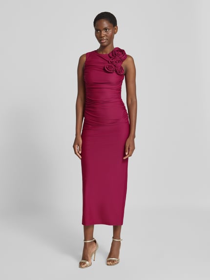 Frauenmodel trägt Cocktailkleid mit floralen Applikationen Modell 'DONA' von YAS in Dunkelrot, figurbetont, Maxikleid, Ganzkörperansicht von vorne.