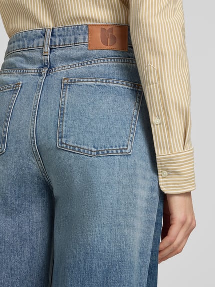 Frauenmodel trägt Wide Leg Jeans mit Fransensaum Modell 'MISLAV' von ba&sh, reine Baumwolle, Gesäßtaschen, Nahaufnahme Rückansicht.