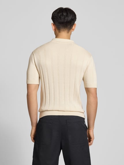 Männermodel trägt Slim Fit Strick-Poloshirt mit Label-Stitching von REVIEW in Creme mit Zopfmuster, Reine Baumwolle, Rückenlänge 67 cm, Ganzkörperansicht Rückansicht.