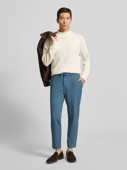 Männermodel trägt Slim Fit Stoffhose mit elastischem Bund von MCNEAL in Blau, Material-Mix mit Viskose-Anteil, Ganzkörperansicht von vorne.