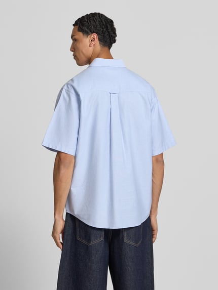 Männermodel trägt Regular Fit Freizeithemd mit Button-Down-Kragen Modell 'Braxton' von Carhartt Work In Progress in Hellblau, Struktur glatte Baumwolle, mit Brusttasche und Label-Stitching; Reine Baumwolle, Rückenlänge 75 cm, Schulterbreite 50 cm, Ärmellänge 28 cm, Ganzkörperansicht Rückansicht.