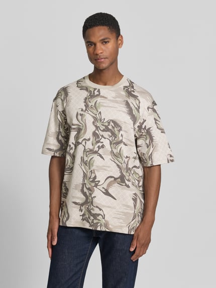 Männermodel trägt Regular Fit T-Shirt aus reine katoen Modell 'TE-BARB' van BOSS Orange met camouflageprint en label patch in jersey, Ganzlichaamsaanzicht van voren.