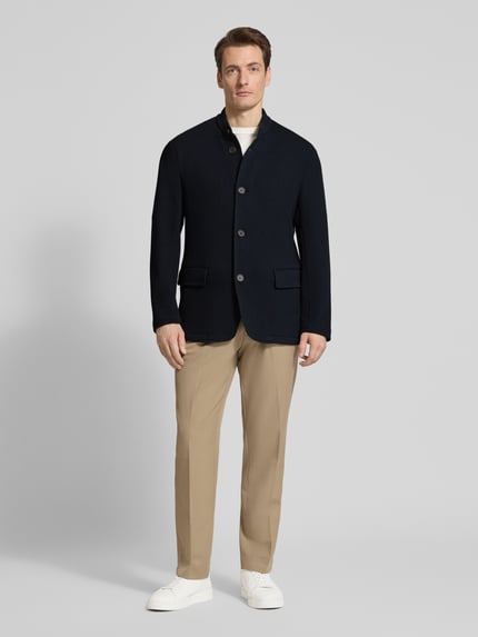 Männermodel trägt Slim Fit Sakko mit Stehkragen und Pattentaschen von Emporio Armani aus Material-Mix mit Viskose-Anteil, Ganzkörperansicht von vorne.