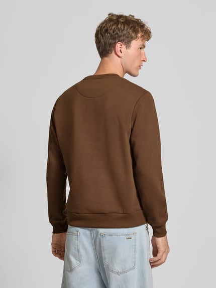 Männermodel trägt Regular Fit Sweatshirt mit Baumwoll-Anteil Modell 'Bradley' von JACK & JONES in Braun, glatte Struktur, Ganzkörperansicht Rückansicht. Kontext: Herren Sweatshirt, Material-Mix mit Baumwoll-Anteil, Rundhalsausschnitt, Langarm, gerippte Blende und Abschlüsse, Logo-Label, Rückenlänge 66 cm, Ärmellänge 64 cm.