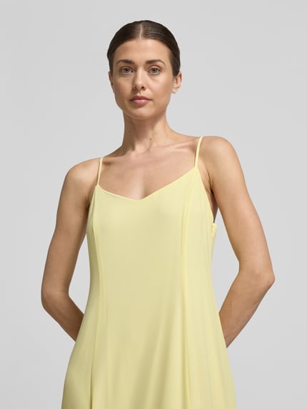 Frauenmodel trägt Ausgestelltes Cocktailkleid mit verstellbaren Spaghettiträgern Modell 'RAELYNN' von Vero Moda in Two-Tone-Optik, V-Ausschnitt, Maxi-Länge, verdeckter Reißverschluss, Nahaufnahme Oberkörper.