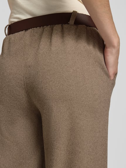 Frauenmodel trägt Regular Fit Weite Hose mit Bundfalten von ZABAIONE, strukturierte Webware, unifarben, Nahaufnahme Hüfte und Gesäß.