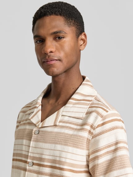Männermodel trägt Regular Fit Freizeithemd mit Reverskragen Modell 'Carlo' von Zuitable, beige-brauner Allover-Look, Baumwoll-Mix, Nahaufnahme Oberkörper. Rückenlänge bei Größe M 70 cm, Schulterbreite 45 cm, Ärmellänge 26 cm.