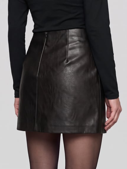 Frauenmodel trägt Mini-Rock mit Nietenapplikation von ONLY in matter Lederoptik mit Struktur, A-Linie, Rückansicht, Ganzkörperansicht.