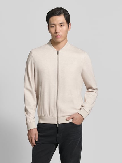 Männermodel trägt Blouson aus Viskose-Mix mit Zweiwege-Reißverschluss von Roy Robson in Beige mit Stehkragen, Regular-Fit, Nahaufnahme Oberkörper. Rückenlänge 68 cm, Schulterbreite 47 cm, Brustweite 59 cm, Ärmellänge 68 cm, Eingrifftaschen, Stretch-Anteil.