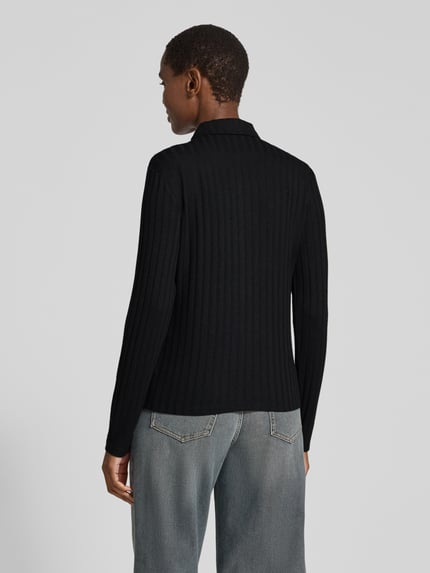 Frauenmodel trägt Cropped Langarmshirt mit durchgehender Knopfleiste Modell 'Sitami' von OPUS in Schwarz, Rippstrick-Struktur, Ganzkörperansicht Rückansicht.