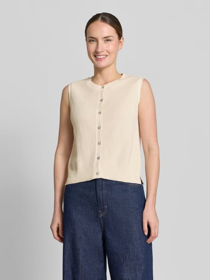 Modelka nosi Weste mit Strukturmuster von Christian Berg Woman z czystej bawełny, krój regular fit, jasny beż, przód z guzikami, fakturowana powierzchnia, długość tyłu w rozmiarze S: 50 cm, całkowity widok z przodu.
