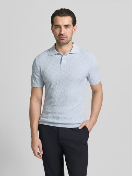 Männermodel trägt Regular Fit Poloshirt mit Strukturmuster von MCNEAL in Hellblau, reine Baumwolle, Strick-Optik, Ganzkörperansicht von vorne.