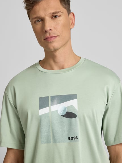 Männermodel draagt Relaxed Fit T-Shirt uit pure katoen model 'JOIN' van BOSS Green, mintgroen met motiefprint, Nahaufnahme Oberkörper.