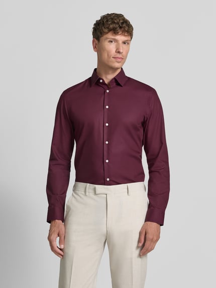 Männermodel trägt Slim Fit Business-Hemd mit Kentkragen von Jake*s in Bordeaux, weiße Knopfleiste, reine Baumwolle, Ganzkörperansicht von vorne.