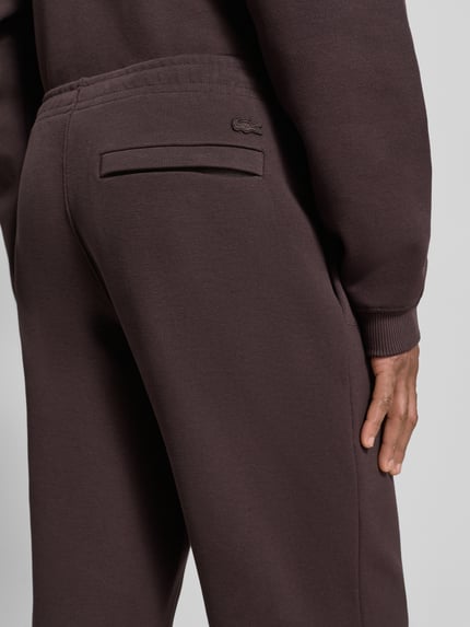 Männermodel trägt Regular Fit Sweatpants aus Baumwoll-Mix von Lacoste, Optik: Unifarben, Logo-Stitching, Detailaufnahme Rückansicht.
