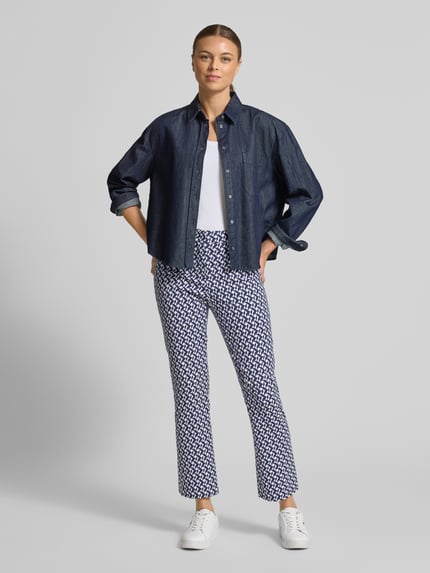 Frauenmodel trägt Stoffhose mit geometrischem Allover-Print Modell 'Maika' von Raffaello Rossi im Flared Fit aus Baumwoll-Mix, Ganzkörperansicht von vorne.