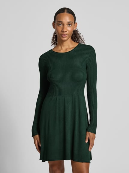 Frauenmodel trägt Regular Fit Strickkleid aus Viskose-Mix Modell 'ALMA' von ONLY, dunkelgrün mit feiner Rippenstruktur, Nahaufnahme Oberkörper, Damen Strickkleid von ONLY.