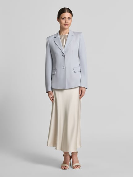 Modelka nosi Blazer mit Reverskragen und Pattentaschen von Jake*s Collection, mieszanka materiałów z dodatkiem streczu, taliowany krój, kołnierz z połami, listwa guzikowa, kieszenie z patką, długość tyłu w rozmiarze 36: 65 cm, szerokość w rozmiarze 36: 46 cm, długość rękawów w rozmiarze 36: 63 cm, jasnoniebieski, gładka faktura, cały przód, widok na całe ciało z przodu.