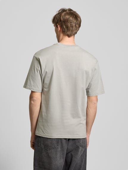 Männermodel trägt Relaxed Fit T-Shirt aus reiner Baumwolle von REVIEW in Hellgrau mit überschnittenen Schultern, Ganzkörperansicht Rückansicht. Rückenlänge bei Größe M: 68 cm, Logo-Stickerei, kurzärmeliges Design, reine Baumwolle.