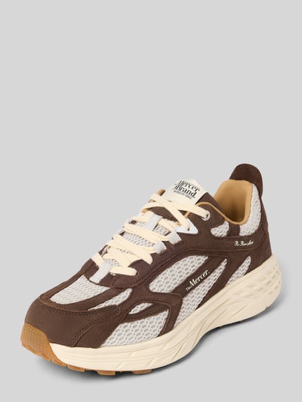 Produktfoto, Sneaker mit Kontrastbesatz von The Mercer, abgerundete Form, strukturierte Sohle, braun-beige Farbkombination, seitliche Ansicht.