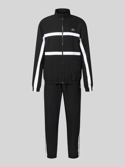 Produktfoto, Regular Fit Trainingsanzug mit Kontraststreifen von Lacoste Sport in Schwarz mit weißen Streifen, elastische Bündchen, Reißverschluss, wasserabweisend, Logo-Details, seitliche Taschen
