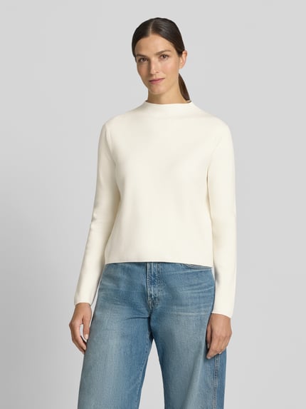 Frauenmodel trägt Strickpullover aus Viskose-Mix Modell 'CHIMNEY' von MANGO in Creme mit Stehkragen, Regular Fit, Ganzkörperansicht von vorne. Rückenlänge 56 cm, Ärmellänge 59 cm.