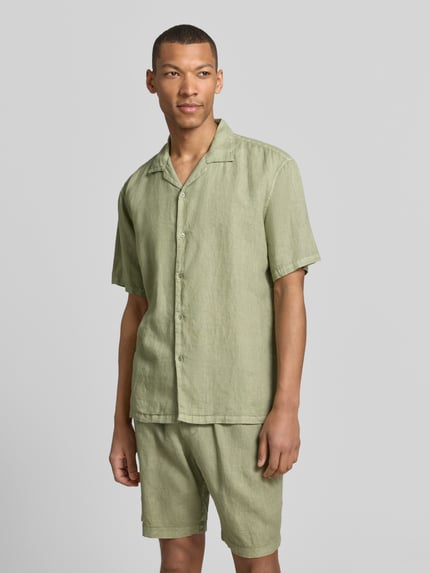 Männermodel trägt Regular Fit Leinenhemd mit Reverskragen von MCNEAL in hellem Grün, reine Leinenstruktur, Kurzarm, Knopfleiste, Ganzkörperansicht von vorne.