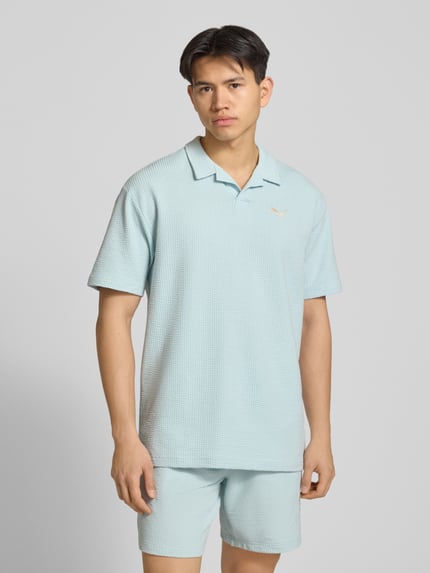 Männermodel trägt Regular Fit T-shirt mit logo-stitching van PUMA PERFORMANCE in lichtblauw katoenmix met stretch, structuurpatroon, reverskraag, ruglengte maat M 74 cm, ganzlichaamsaanzicht van voren.