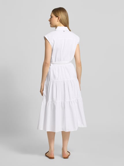 Frauenmodel trägt Hemdblusenkleid mit Gürtel und Knopfleiste von MICHAEL Michael Kors in Weiß, tailliert, Midilänge, Ganzkörperansicht Rückansicht.