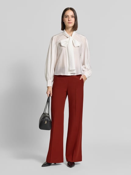 Frauenmodel trägt Weite Hose mit Bügelfalten von windsor., Material-Mix mit Viskose-Anteil, Slim Fit, rote Farbe, Bundweite 37 cm, Innenbeinlänge 84 cm, Eingrifftaschen, Ganzkörperansicht von vorne.