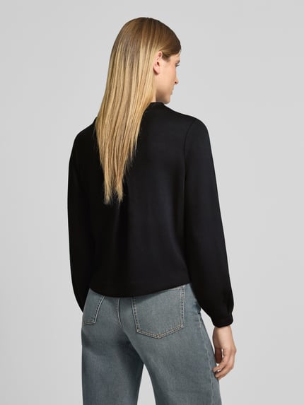 Vrouwenmodel draagt Sweatshirt met ausgestelltem Ärmel Modell 'Gisinna' van OPUS, zwart, unikleurig, viscosemix, afgeronde zoom, Lange mouw met uitlopende manchetten, ronde hals, Ganzlichaamsaanzicht achteraan.