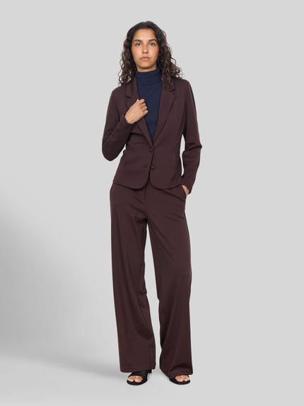 Kobiece modelka nosi jednokolorowy żakiet zapinany na 2 guziki Slim Fit z kołnierzem z połami, długi rękaw, Model 'SC-DANIELA 1' od Soyaconcept, z dodatkiem wiskozy, widok całej sylwetki z przodu.