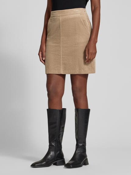 Frauenmodel trägt Mini-Rock Modell 'Reah horizon' von OPUS in Beige, Cordstruktur, unifarben matt, Teilungsnähte, Ganzkörperansicht von vorne.