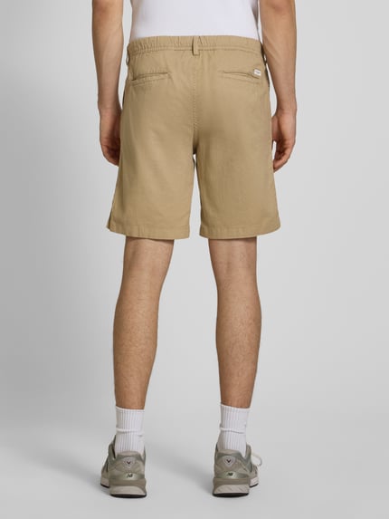 Männermodel trägt Shorts mit Tunnelzug Modell 'JAIDEN' von Jack & Jones, Baumwoll-Leinen-Mix, Regular-Fit, beige, Ganzkörperansicht Rückansicht.