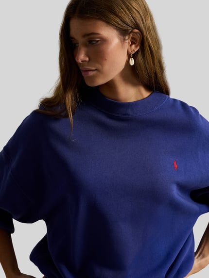 Frauenmodel trägt Regular Fit Sweatshirt aus Baumwoll-Mix von Polo Ralph Lauren in Unifarbe Blau, Logo-Detail, Nahaufnahme Oberkörper.