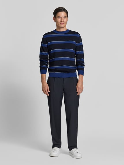Männermodel trägt Strickpullover mit Struktur-Muster von Armani Exchange in Blau mit Rundhalsausschnitt, lockerer Schnitt, Ganzkörperansicht von vorne.