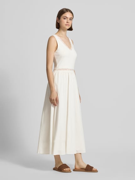 Vrouwenmodel draagt Midikleid mit Spitze Modell 'Nami' van OH APRIL in wit, katoen- en viscosemix, getailleerd model, V-hals met kant, naadritssluiting, ruglengte maat S 127 cm, borstwijdte maat S 45 cm, Ganzkörperansicht van voren.