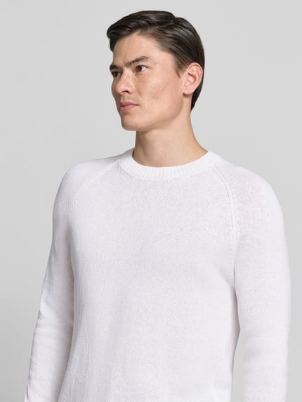 Mannelijk model draagt 'Strickpullover aus Baumwoll-Kaschmir-Mix mit Rundhalsausschnitt' van GRAN SASSO in slim fit, bouclé-look, wit; detailopname bovenlichaam.