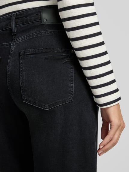 Frauenmodel trägt dunkelblaue Barrel Jeans aus Baumwoll-Mix von CAMBIO, sichtbare Gesäßtasche, Nahaufnahme Rückansicht, Damen Barrel Jeans von CAMBIO.