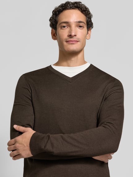 Männermodel trägt sweter z dzianiny aus mieszanka wełny, krój regular fit, dekolt w serek, prążkowane wykończenia, Christian Berg Men, Długość tyłu w rozmiarze M: 71 cm, Długość rękawów w rozmiarze M: 73 cm, brązowy, gładka tekstura, Nahaufnahme Oberkörper.