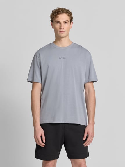 Męski model nosi Relaxed Fit T-Shirt aus reiner Baumwolle Modell 'TEE 10' od BOSS Green w jasnoszarym kolorze, gładka faktura, Ganzkörperansicht von vorne.