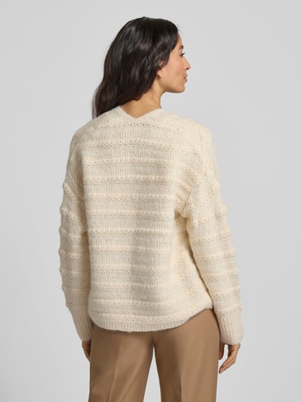 Frauenmodel trägt Strickjacke mit Strukturmuster Modell 'Wave' von FREE/QUENT in Creme, Material-Mix mit Woll-Anteil, Relaxed Fit, Ganzkörperansicht Rückansicht.