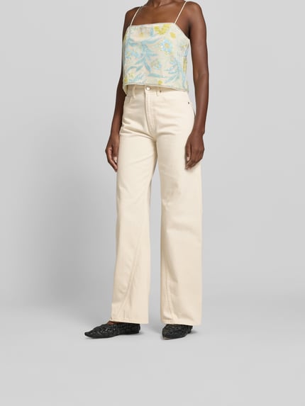Frauenmodel trägt Wide Fit Jeans aus reiner Baumwolle von Anine Bing in creme mit 5-Pocket-Design und Ziernähten, Ganzkörperansicht von vorne.